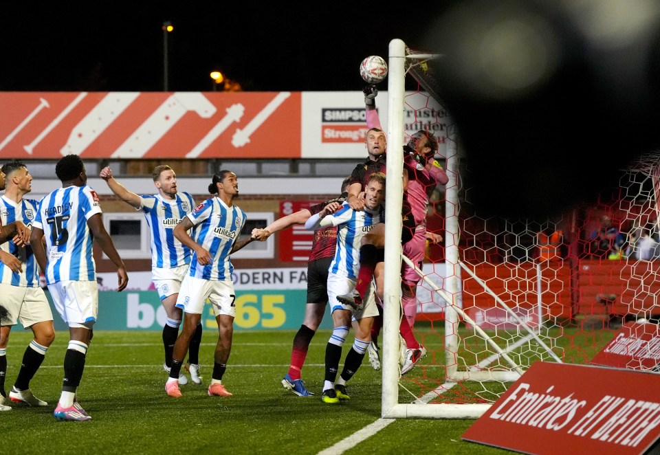 O goleiro do Huddersfield, Chris Maxwell, só conseguiu acertar o lance em sua própria rede