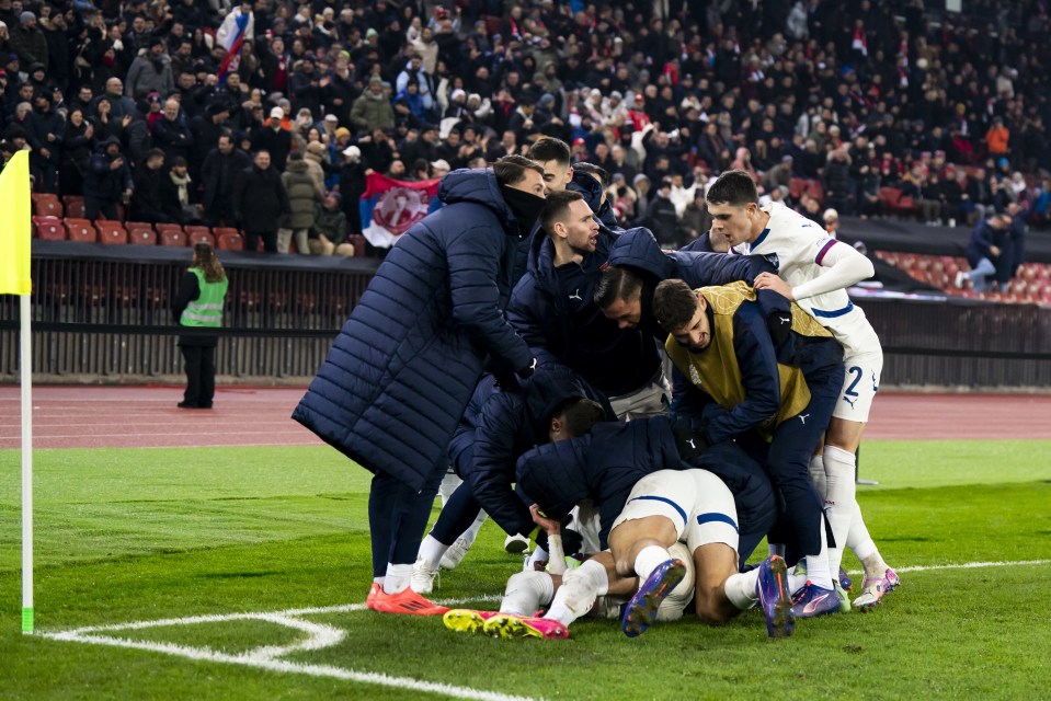 Jogadores da Sérvia empilhados em cima de Terzic para comemorar o empate tardio