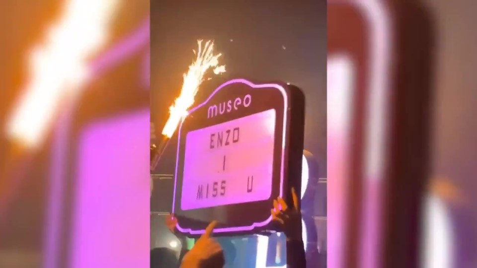 Alguém estava segurando uma placa 'Enzo I Miss U' perto de onde os jogadores estavam