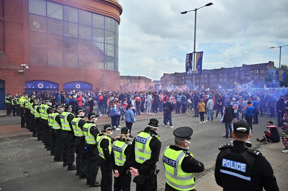 A polícia faz fila enquanto os fãs comemoram a conquista do título da Premiership da Escócia em Glasgow em 2021 em Glasgow